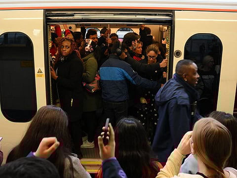 Commuters board a crowded train at Stratford Station in London on November 10, 2022. Millions of Londoners faced travel misery as another strike by Underground staff shut down most of the so-called "tube" network, including almost all lines and city centre stations.