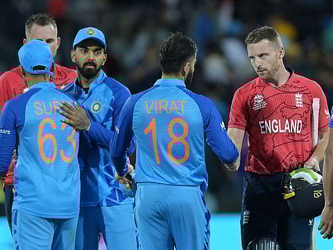 England's captain Jos Buttler (R) shakes hands with India's Virat Kohli (C) as he celebrates after victory in the T20 World Cup 2022 semi-final match at The Adelaide Oval in Adelaide on November 10, 2022.