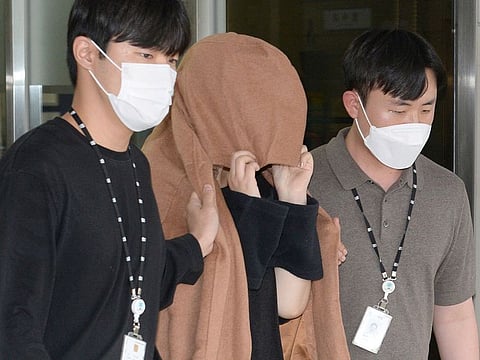 A woman, center, leaves to the Seoul Central District Prosecutors' Office at Ulsan Jungbu police station in Ulsan, South Korea, on Sept. 15, 2022.