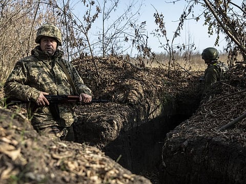 Ukrainian soldiers take shelter from Russian shelling in a trench in the Kherson region of southern Ukraine on Nov. 5, 2022.