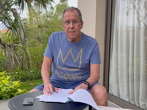 Russian Foreign Minister Sergei Lavrov reads documents on a patio in Bali on November 14, 2022, in this still image taken from video uploaded on the Telegram channel of Foreign Ministry Spokeswoman Maria Zakharova.