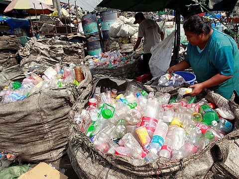 People sort through plastic bottles they collected and are about to sell at a junk shop in Manila.
