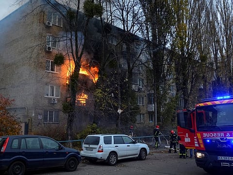 Firefighters work to put out a fire in a residential building hit by a Russian missile strike in Kyiv on November 15, 2022.