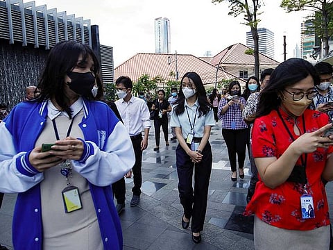 People gather as they are evacuated outside a building following an earthquake in Jakarta, Indonesia, November 21, 2022.