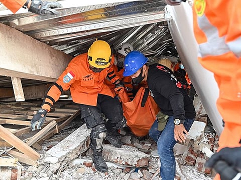 Rescue workers carry the body of a victim in Cianjur