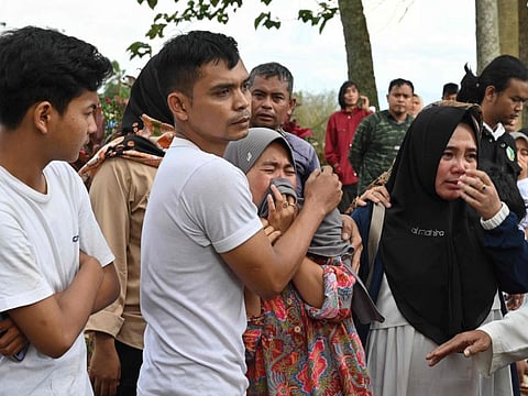 Relatives cry during the funeral of 48-year-old victim Husein, who was killed while building a house, at a village near Cianjur on November 22, 2022, following a 5.6-magnitude earthquake.