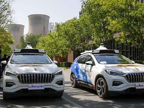 Baidu Apollo Robotaxis pass by a passenger pickup point setup at the Shougang Park in Beijing. File photo taken on May 2, 2021.
