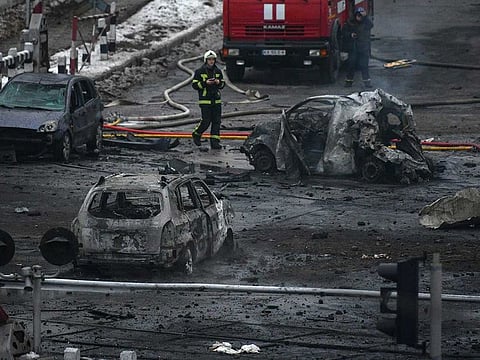 Emergency personnel walk near burnt out cars at the scene of a shelling in Kyiv, Ukraine, Wednesday. File photo taken on Nov. 23, 2022.
