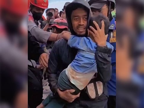 This frame grab taken from mobile phone video footage released by Bogor Administration shows a six-year-old boy being pulled out of the rubble in Cianjur, West Java.