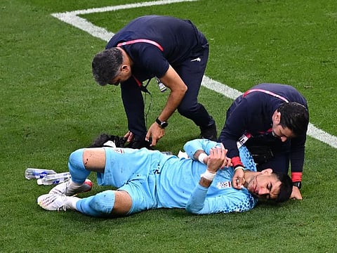 Iran's goalkeeper Alireza Beiranvand receives medical attention following a crash of heads with Iran's defender against England at Khalifa International Stadium in Doha on Monday.