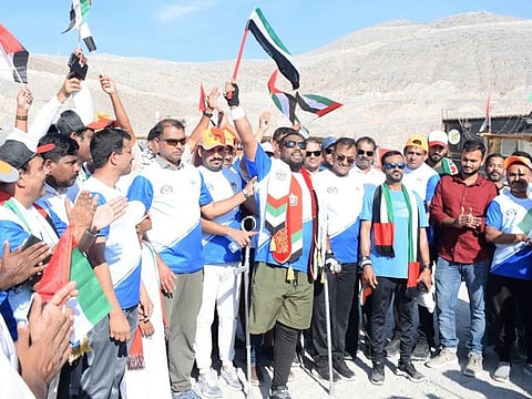 Panakkadan Muhammed Shafeeq waves the UAE flag after his hike up Jebel Jais