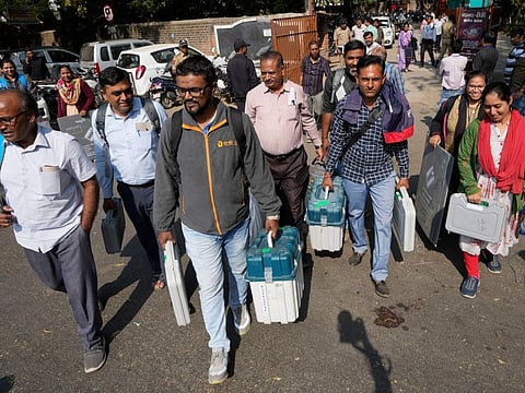 Election officials carrying electronic voting machines leave for their respective polling stations on the eve of the second phase of Gujarat state legislature elections in Ahmedabad, India, Sunday, Dec. 4, 2022.