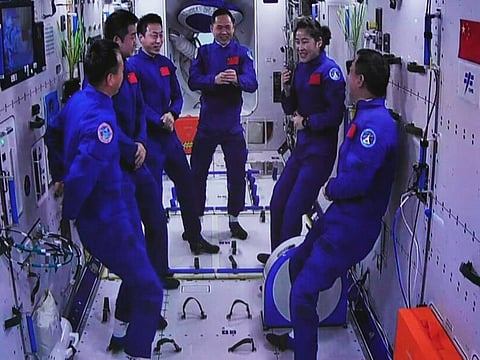 In this photo released by Xinhua News Agency, an image captured off a screen at the Jiuquan Satellite Launch Center in northwest China shows the Shenzhou-15 and Shenzhou-14 crew chatting after a historic gathering in space on Wednesday, Nov. 30, 2022. Three Chinese astronauts docked early Wednesday with their country’s space station, where they will overlap for several days with the three-member crew already onboard and expand the facility to its maximum size.