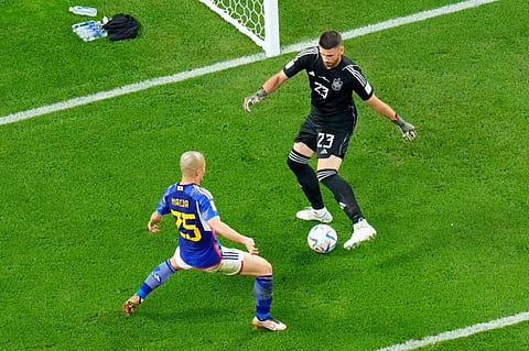 Japan's Daizen Maeda (left) challenges Spain's goalkeeper Unai Simon during the World Cup group E match at the Khalifa International Stadium in Doha, Qatar.