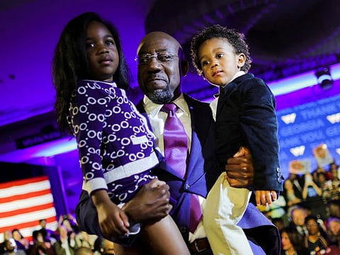 U.S. Senator Raphael Warnock (D-GA) holds his daughter Chloe and his son Caleb in his arms during an election night party after a projected win in the US midterm runoff election between Warnock and his Republican challenger Herschel Walker in Atlanta, Georgia, US, December 6, 2022.