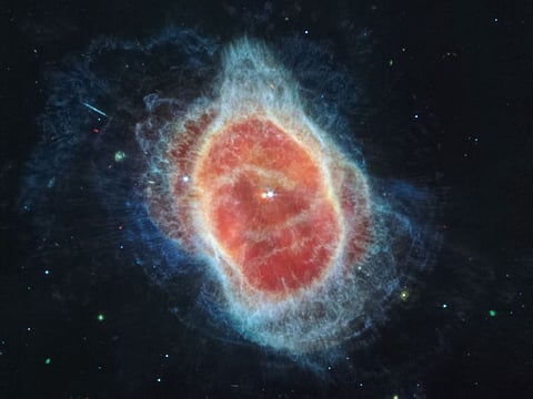 James Webb Space Telescope (JWST) has revealed the cloak of dust around the second star, shown at left in red, at the center of the Southern Ring Nebula.