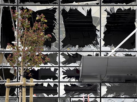 Broken windows of the terminal at Brussels national airport are seen during a ceremony following bomb attacks in Brussels metro and Belgium's National airport of Zaventem, Belgium, March 23, 2016.