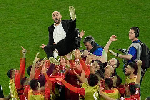 Morocco's head coach Walid Regragui is thrown in the air at the end of the World Cup round of 16 match against Spain.