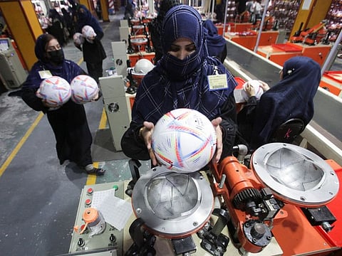 Workers conduct the final check of balls inside the soccer ball factory in Sialkot on December 2, 2022.