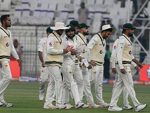 Pakistan's captain Babar Azam (right) and his teammates walk back to the pavilion at the end of the second day of the second cricket Test match against England at the Multan Cricket Stadium in Multan.