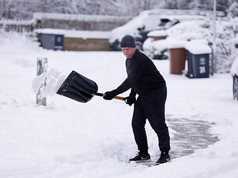 A man clears snow as cold weather continues in Hertford, Britain, December 12, 2022.