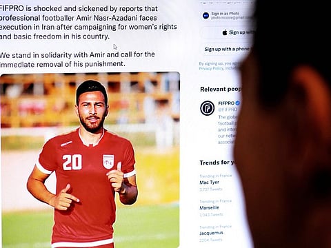 A person in the Cypriot capital Nicosia checks a tweet on December 13, 2022, by the International Federation of Professional Footballers (FIFPRO) regarding the reported risk of Iranian footballer Amir Nasr-Azadani being sentenced to death in connection with protests which have shaken the country for three months.