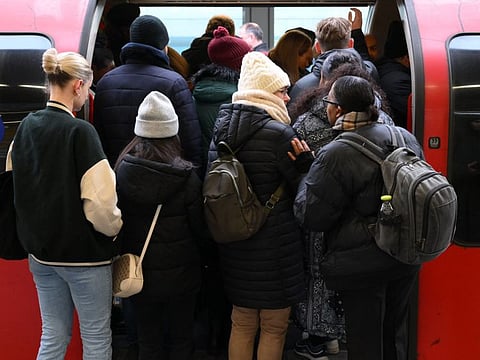 Commuters board an extremely delayed Central Line train at Stratford station in London on December 13, 2022 as rail strikes began a wave of festive walkouts in the country.