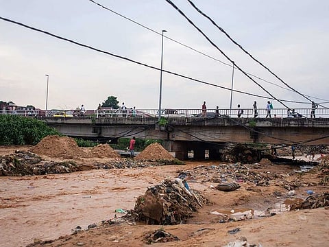 Belongings and debris are washed up by a bridge as residents clean up following torrential rains in Kinshasa,Democratic Republic of Congo Tuesday Dec. 13, 2022. At least 100 people have been killed and dozens injured by widespread floods and landslides caused by the rains.