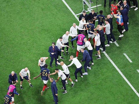 France players are congratulated by staff member as they leave the pitch after they won the Qatar World Cup semi-final match against Morocco at the Al Bayt Stadium in Al Khor, north of Doha on December 14, 2022.