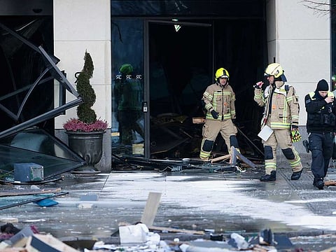 Emergency services work on a street outside a hotel after a leak of the AquaDom aquarium in central Berlin near Alexanderplatz, with water poured out onto the street, in Berlin, Germany, December 16, 2022.
