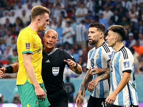Australia's Harry Souttar clashes with Argentina's Nicolas Otamendi and Lisandro Martinez as referee Szymon Marciniak intervenes during the Round of 16.