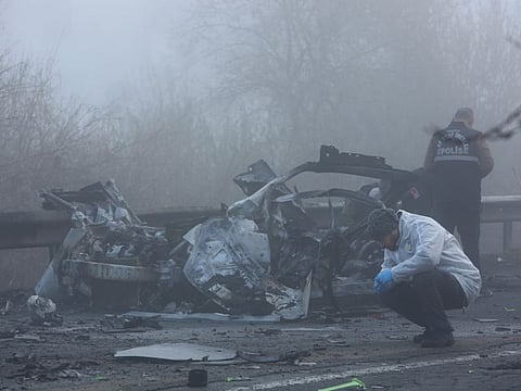 Forensic experts examine the site after a bomb exploded in a roadside vehicle while a police minibus passed by, in Diyarbakir, on December 16, 2022.