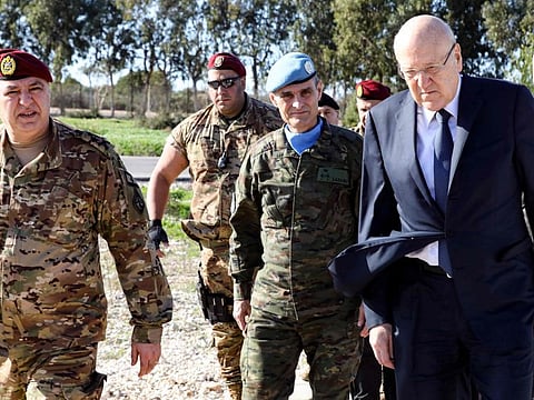 Lebanon's caretaker Prime Minister Najib Mikati (right) accompanied by the Head of Mission and Force Commander of the United Nations Interim Force in Lebanon (UNIFIL) Aroldo Lazaro Saenz (second right), visiting the UNIFIL headquarters in the southern Lebanese town of Naqoura, on December 16, 2022, a day after an Irish UNIFIL soldier was killed in the region. - An Irish soldier of the UN peacekeeping force in south Lebanon near the Israeli border was killed and three wounded after their convoy came under fire, Irish officials said yesterday. (Photo by STRINGER / DALATI AND NOHRA / AFP) / === RESTRICTED TO EDITORIAL USE - MANDATORY CREDIT "AFP PHOTO / HO / DALATI AND NOHRA" - NO MARKETING - NO ADVERTISING CAMPAIGNS - DISTRIBUTED AS A SERVICE TO CLIENTS ===