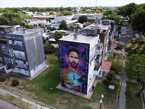 Pedestrians walk past a mural depicting Argentine star Lionel Messi near the home where he was born, in Rosario, Argentina.