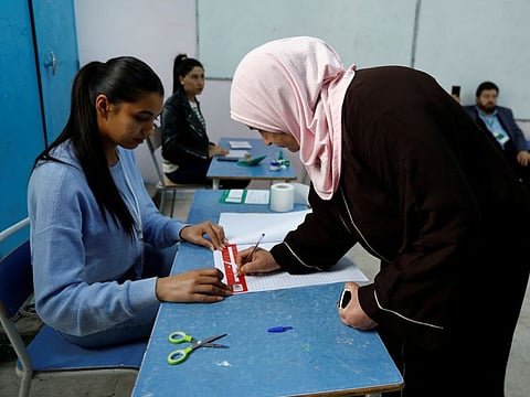 A woman signs in to vote at a polling station during parliamentary election in Tunis on December 17, 2022.