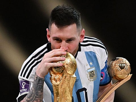 Argentina's captain and forward #10 Lionel Messi kisses the FIFA World Cup Trophy during the trophy ceremony after Argentina won the Qatar 2022 World Cup final football match between Argentina and France.