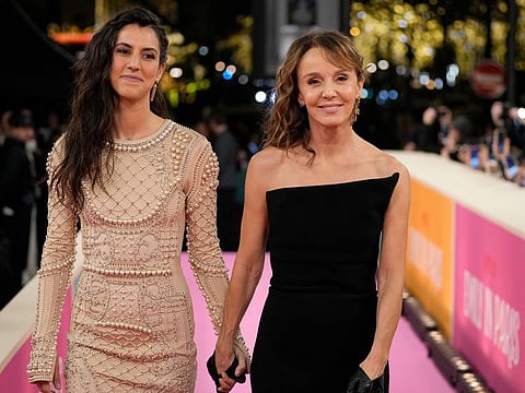 Philippine Leroy-Beaulieu, right, arrives for the World Premiere of the Netflix Series "Emily in Paris" season 3, at the Theatre des Champs Elysees, in Paris, Tuesday, Dec. 6, 2022.