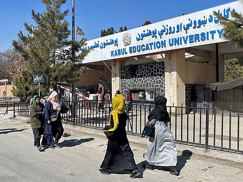 Female students walk in front of the Kabul Education University in Kabul, Afghanistan.
