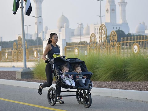 Tifanne Thayme with son Ethan, 3, and daughter Sasha, 1, whizz past Sheikh Zayed Grand Mosque in Abu Dhabi during the marathon