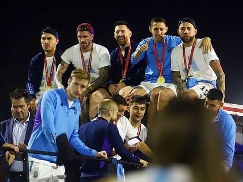 Leandro Paredes, Angel Di Maria, Rodrigo De Paul, Nicolas Otamendi, Paulo Dybala, Cristian Romero and Lionel Messi are seen on the open top bus as it arrives outside the Association of Argentinian Football Headquarters.