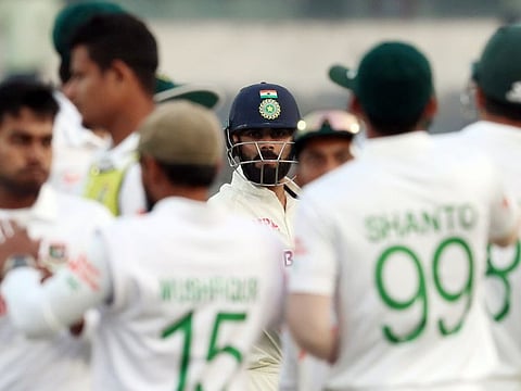 Bangladesh players gather in a team huddle as they celebrate the dismissal of India's Virat Kohli during the Day 3 of the 2nd Test at Shere Bangla National Stadium, in Dhaka.