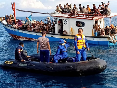 Rohingya refugees rescued by fishermen are seen on a boat behind a patrol boat near the coast of Seunuddon beach in North Aceh, Indonesia, June 24, 2020.