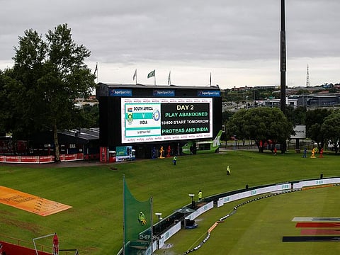 A digital board displays a message that play has been abandoned due to rain during the second day of the first Test cricket match between South Africa and India at SuperSport Park in Centurion
