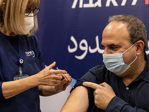 A staffer at the Sheba Medical Centre receives a fourth dose of Pfizer-BioNTech COVID-19 vaccine, in Ramat Gan, Israel, Monday, Dec. 27, 2021. Israel began trials of a fourth dose of coronavirus vaccine on Monday with 150 medical personnel who received a booster dose in August in what is believed to be the first study of its kind.