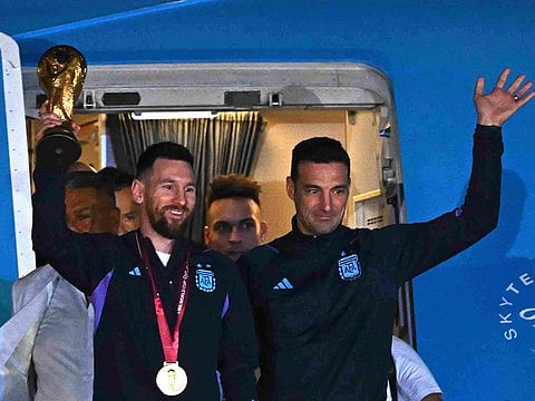 Argentina star Lionel Messi (left) holds the FIFA World Cup Trophy alongside coach Lionel Scaloni. The PSG star will be back at the French club in early January.