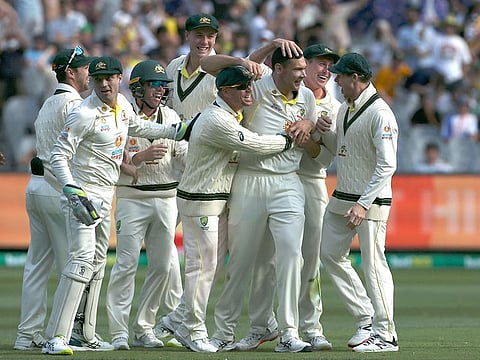 Australia's paceman Scott Boland (C) celebrates his wicket of England's batsman Jack Leach (not pictured) with teammates on day two of the third Ashes Test in Melbourne on December 27, 2021.