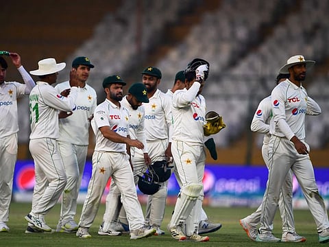 Pakistan's players walk back to the pavilion at the end of the third day play of the first Test match against New Zealand at the National stadium in Karachi.