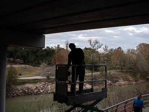 A Houston Humane Society worker prepares a lift to release Mexican free-tailed bats at the Waugh Bridge Bat Colony in Houston, Texas.