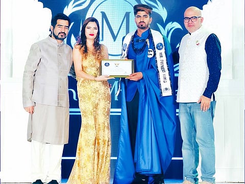 Faizal Shaikh, winner of the Mr UAE Fitness King title receives his award at the Mr. UAE International 2021 pageant, organised by Being Muskaan
