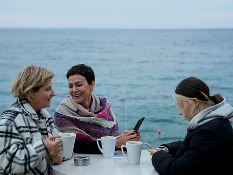Nadine Kalache Maalouf, centre, Celine Elbacha and Elbacha's daughter Morgane, right, sit at a seaside restaurant in the eastern coastal resort of Paralimni, Cyprus.
